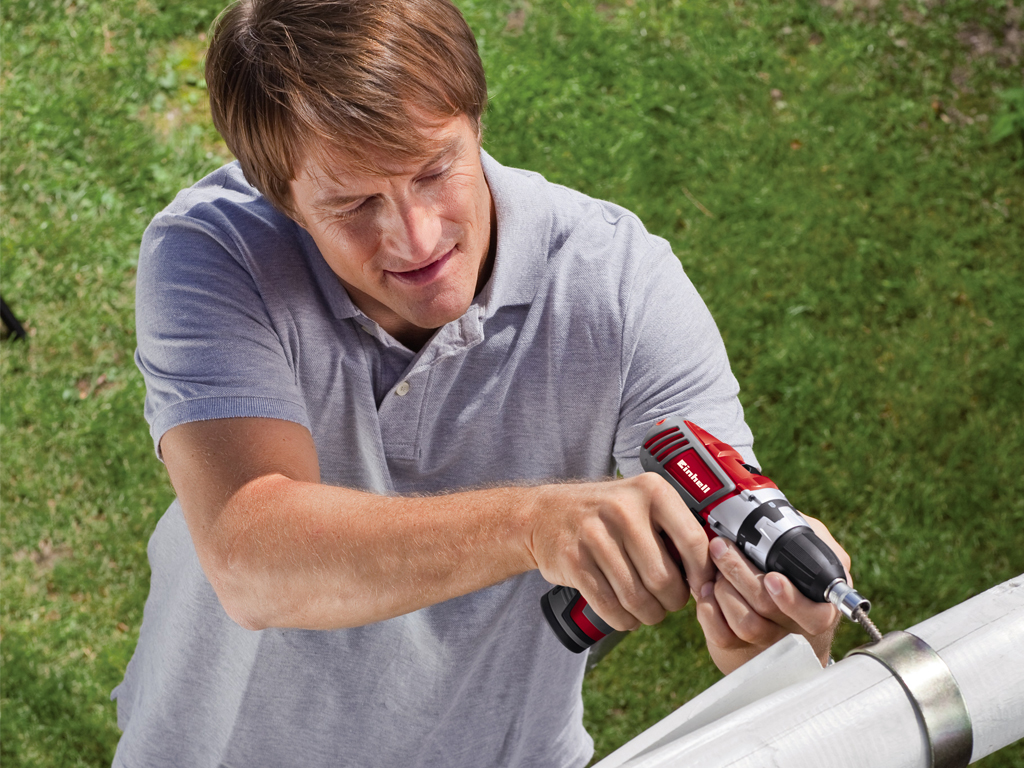 man screws pipe connection to a pipe tightly