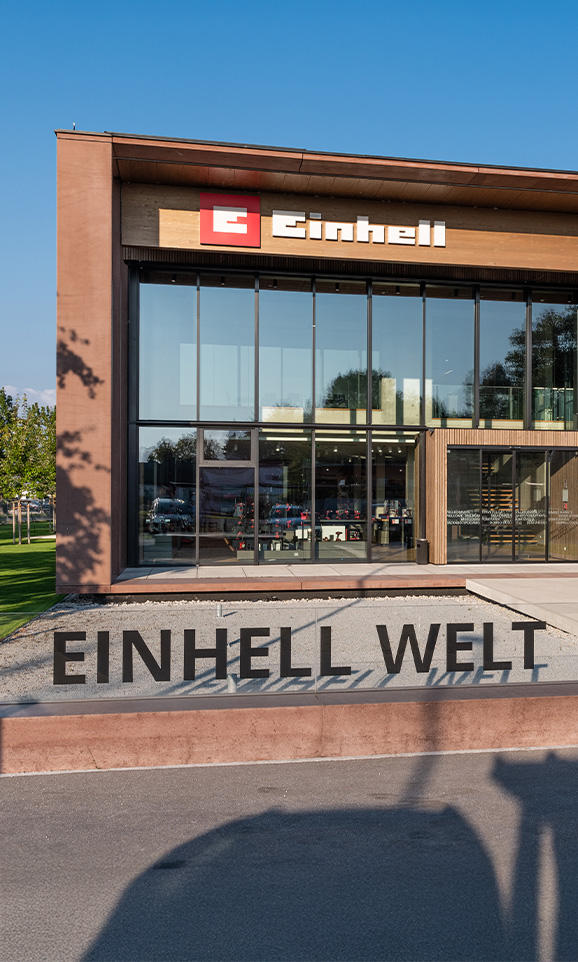 Einhell World: modern company building with Einhell logo and a large group of employees.