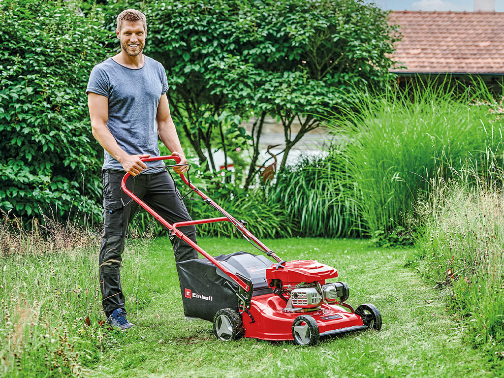 man mows the lawn with a lawn mower