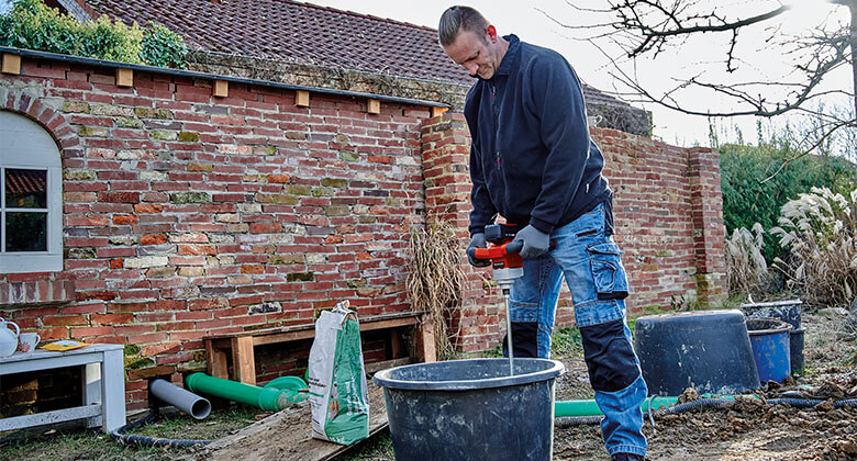 man working with a paint / mortar mixer