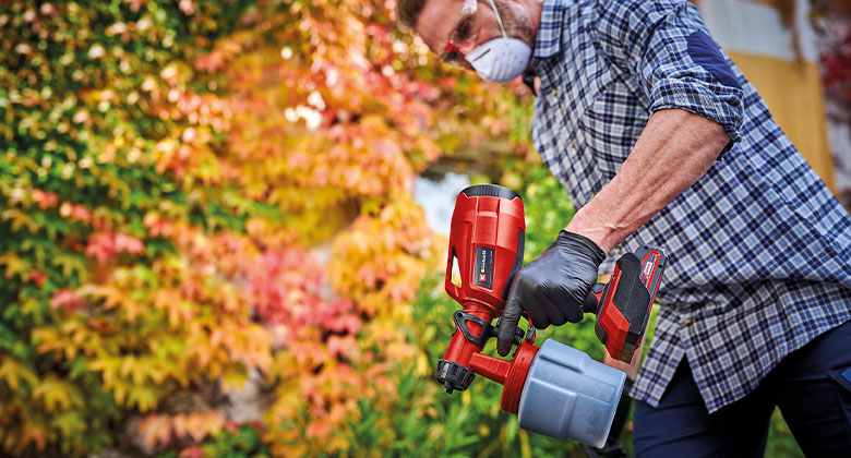 man using cordless paint spray gun