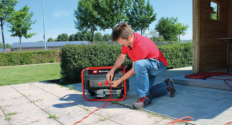 man connecting cable on power generator